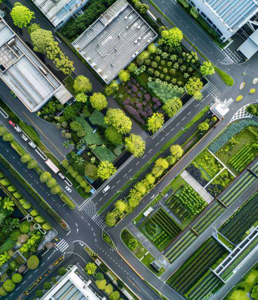 A drone aerial view of a green logistics hub, highlighting the integration of nature with logistics facilities for environmental sustainability